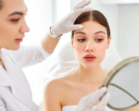 Woman receiving a skincare examination from a professional in a clinical setting.